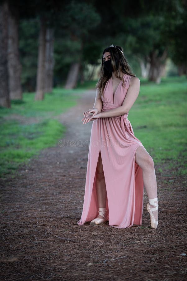 Teenage woman dancing ballet outdoors wearing protective face mask for protection from  Covid-19 Pandemic