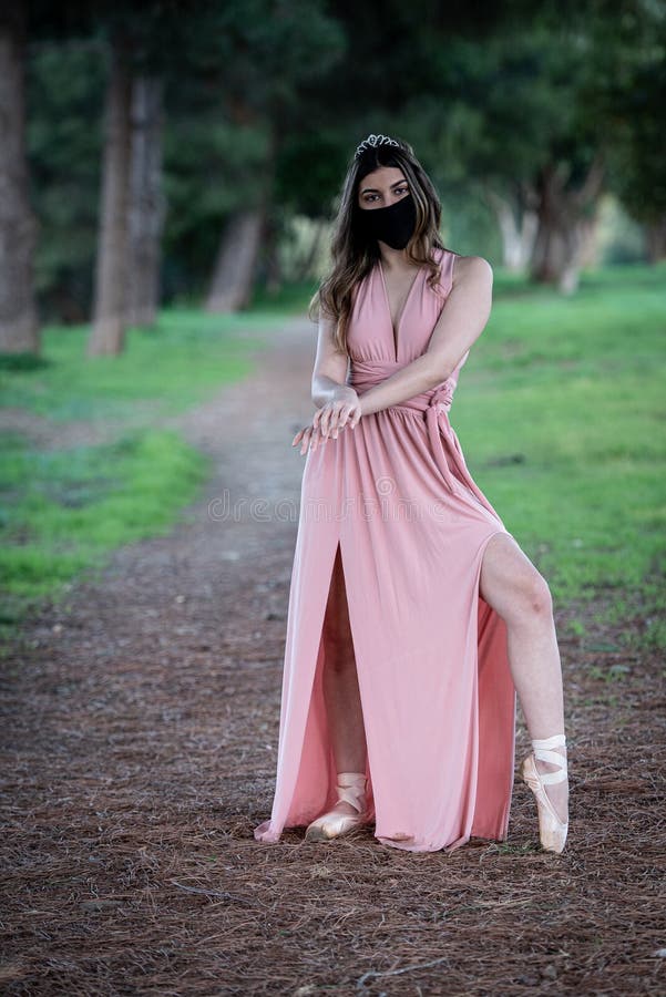 Teenage woman dancing ballet outdoors wearing protective face mask for protection from  Covid-19 Pandemic