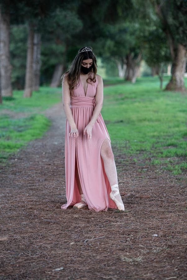 Teenage woman dancing ballet outdoors wearing protective face mask for protection from  Covid-19 Pandemic