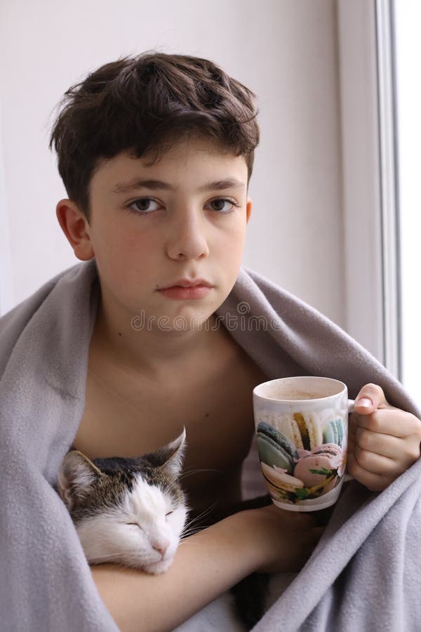 Teenager Boy Drink Hot Cacao Milk Wrap in Rug with Cat Stock