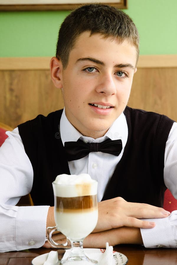 A teenager boy enjoying coffee in a cafe