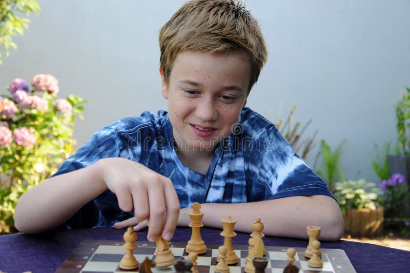 Chlapec šachy, hledá koncentrovaný.