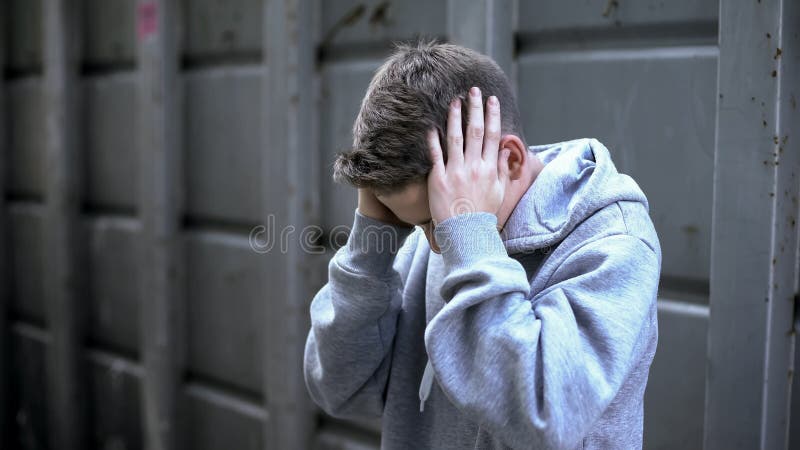 Teenager boy suffering migraine, strong pain, health problems, stressed life, stock photo