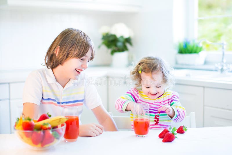 Siblings In Kitchen Eating Breakfast High-Res Stock Photo 
