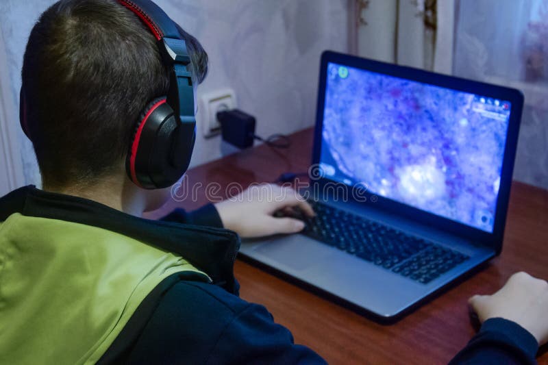 Teen plays computer games, The boy sits at home computer. Reading, boys