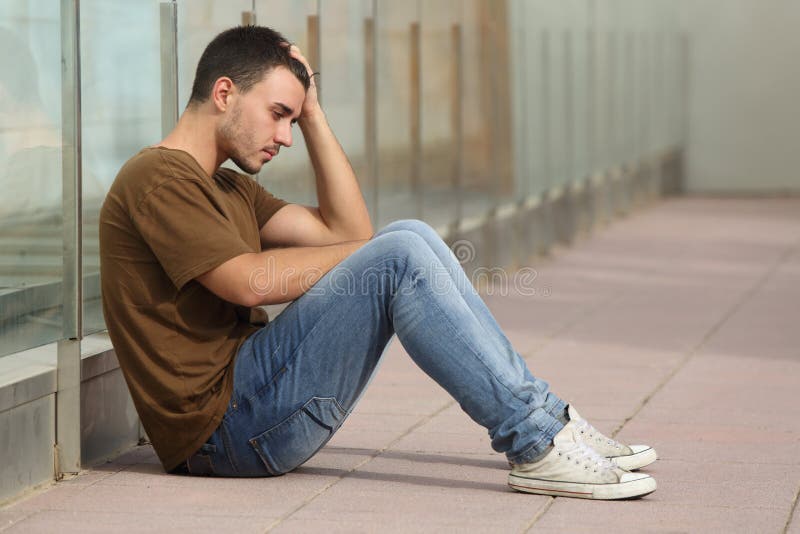 Teenager boy worried sitting on the floor