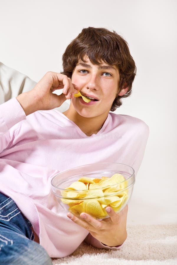 Teenager eating crisps stock images Teenager eating crisps stock images