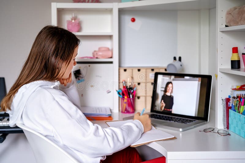 Teenager girl studying online at home looking at teacher giving lesson at laptop screen at quarantine isolation period. Home schooling. Social distancing. Online school test. Child home tutor stock images, royalty-free photos and pictures