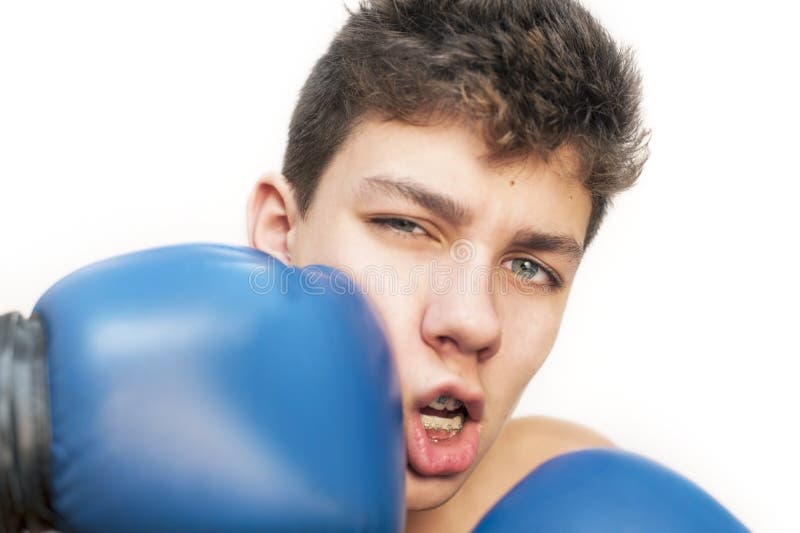 A teenager got a kick on his face with a boxing gloves on a white background. Braces are installed on his teeth