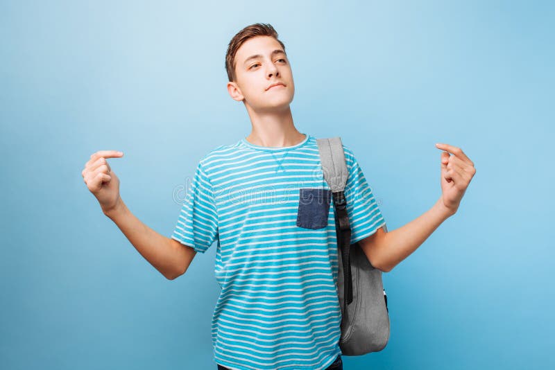 Teenager, the guy shows a finger at himself, on a blue background. 