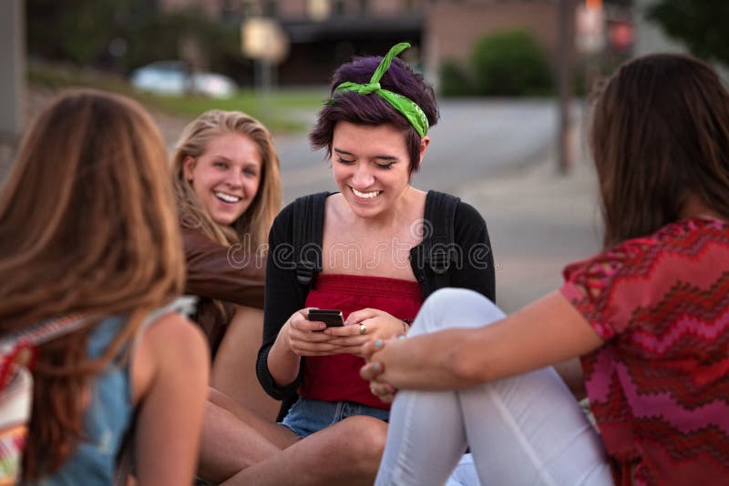 Teenager ispanico con gli amici ed il telefono immagine stock libera da diritti Teenager ispanico con gli amici ed il telefono immagine stock libera da diritti