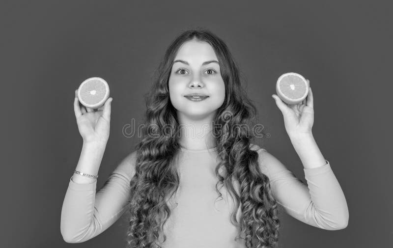 Teenager lächeln orangefarbene Früchte auf lila Hintergrund stockbilder