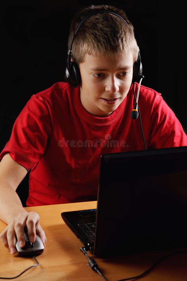 Teenager playing on laptop stock image