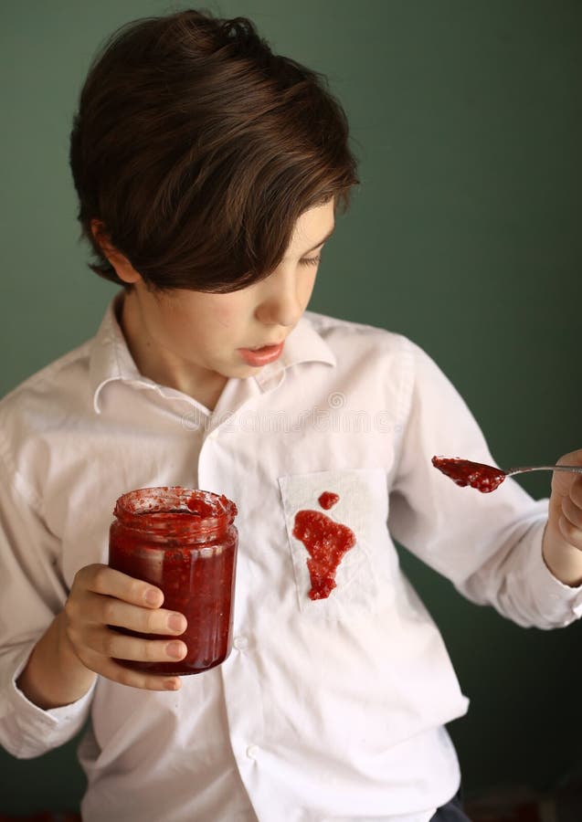 Teenager untidy boy drop jam from jar to white shirt make dirty spot