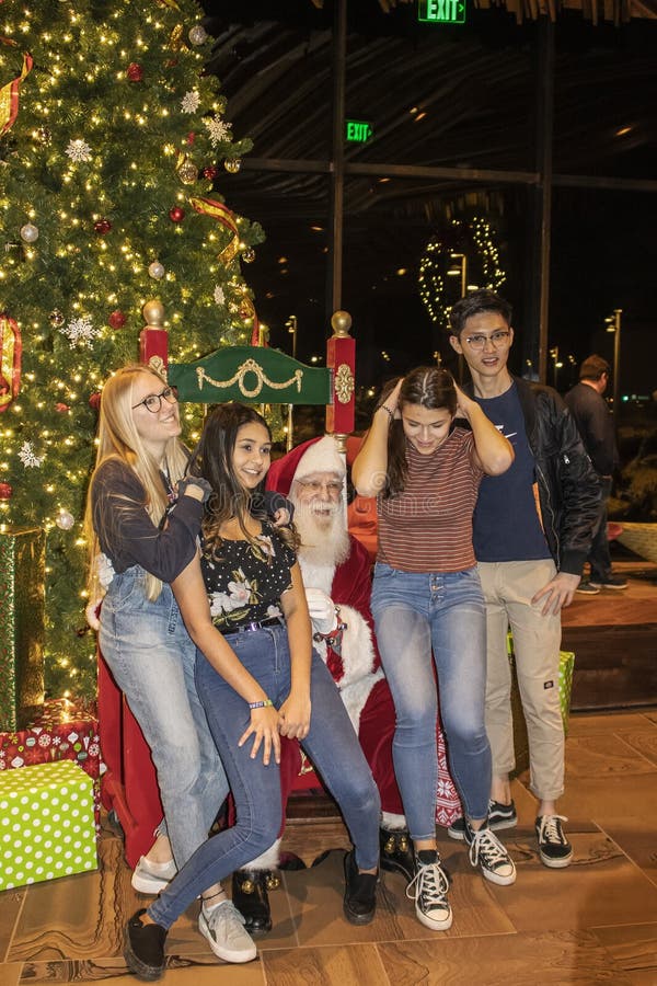 Teenagergruppe stellen sich vor Weihnachtsbaum in der Williams Lodge am Gathering Place vor lizenzfreie stockfotos Teenagergruppe stellen sich vor Weihnachtsbaum in der Williams Lodge am Gathering Place vor lizenzfreie stockfotos