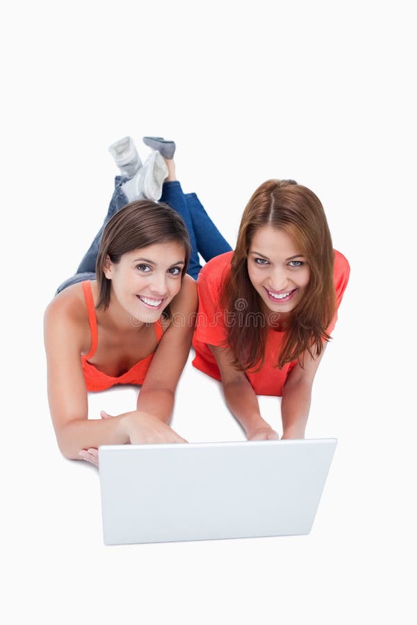 Teenagers lying down behind a laptop royalty free stock images