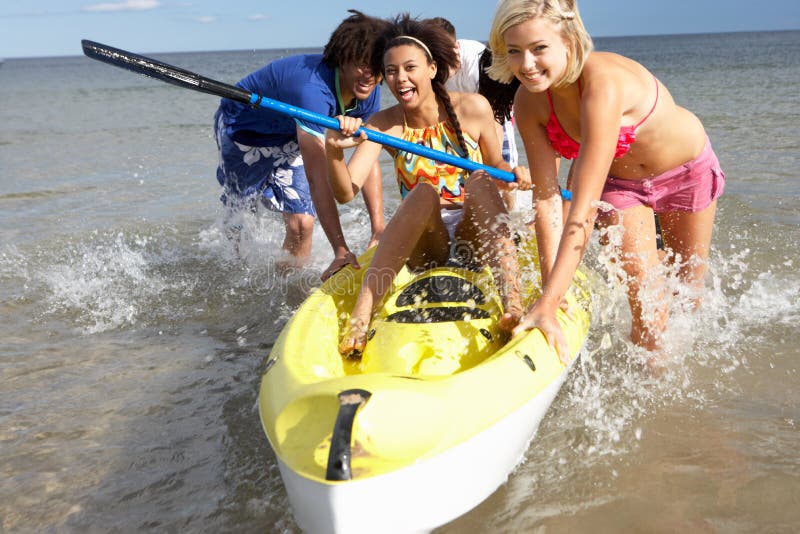 Teenagers in sea with canoe