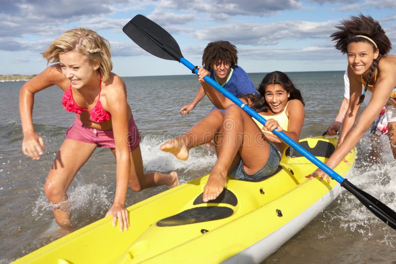 Teenagers in sea with canoe