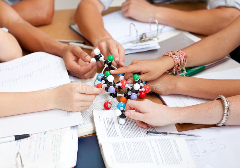 Teenagers studying molecules in a library stock image
