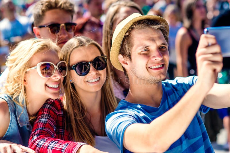 Tínedžeri na letnom hudobnom festivale v dave, ktorí si robia selfie