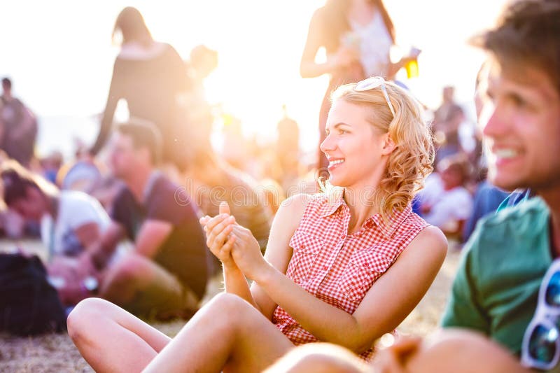 Teenagers at summer music festival, sitting on the ground