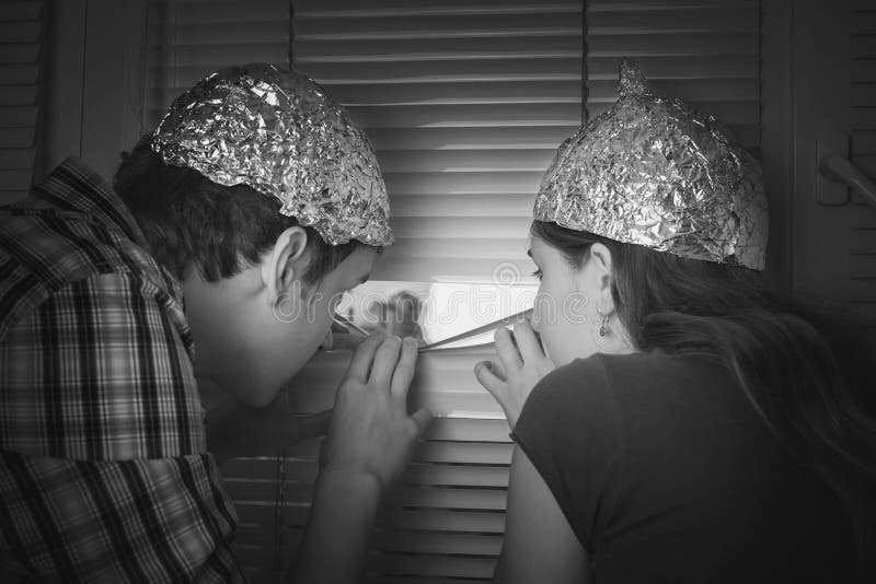 Teens boy and girl in hats made of aluminum foil, protect the b. Teen couple steam boy and girl, protecting the brain with hats made of aluminum foil from the royalty free stock photos Teens boy and girl in hats made of aluminum foil, protect the b. Teen couple steam boy and girl, protecting the brain with hats made of aluminum foil from the royalty free stock photos