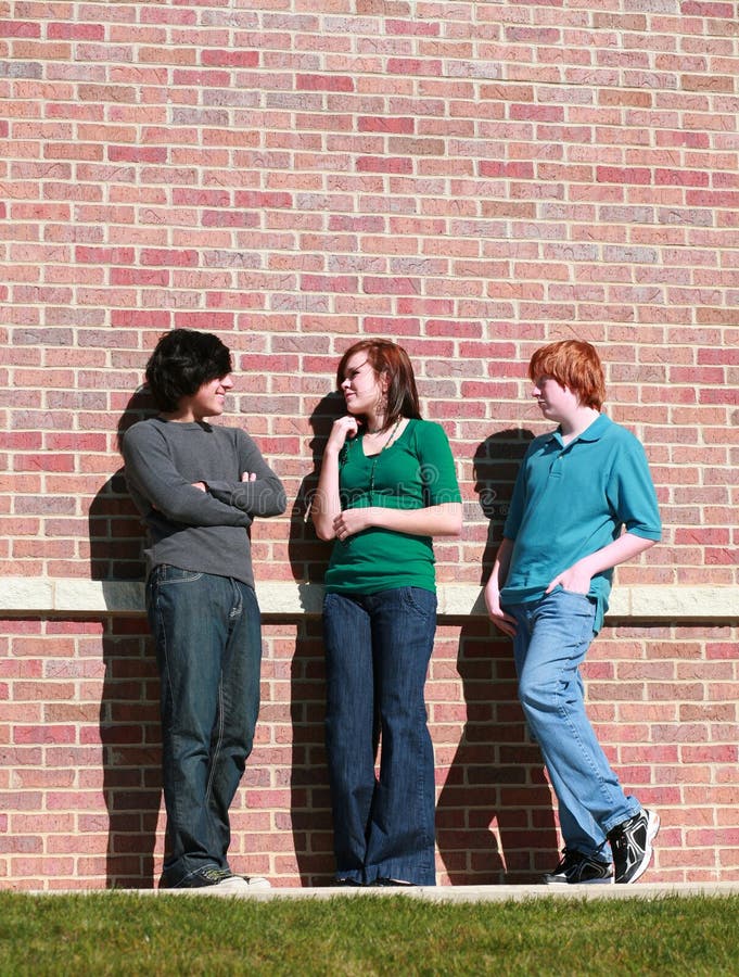 Teens in front of brick wall
