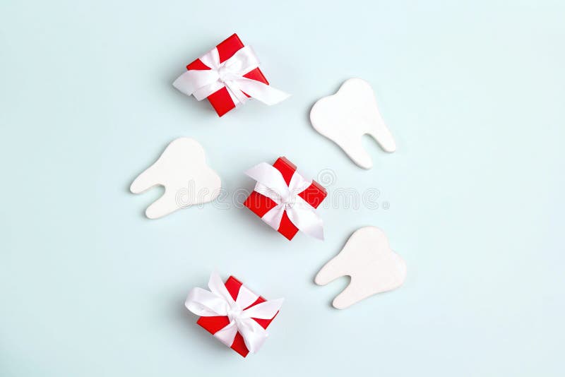 Teeth and gift boxes on a blue background. Happy Dentist`s Day concept
