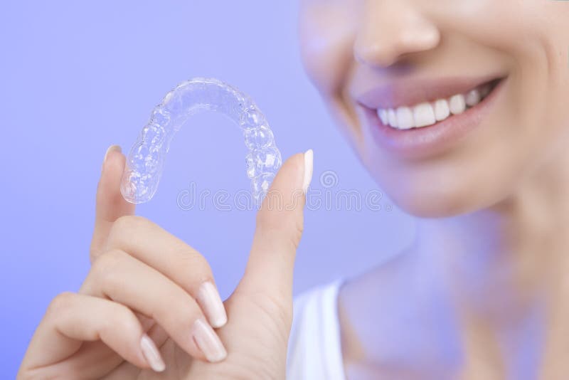 Beautiful Smiling Girl with Tooth Tray (hands Holding Individual Tooth Tray), Methods of Teeth Teeth Whitening and Correction, Close-up (blue filter effect). Beautiful Smiling Girl with Tooth Tray (hands Holding Individual Tooth Tray), Methods of Teeth Teeth Whitening and Correction, Close-up (blue filter effect)