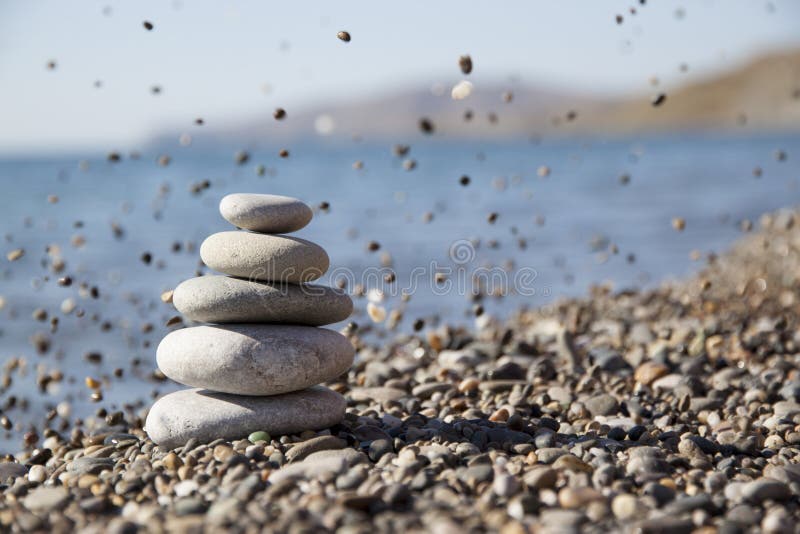 Tegen de achtergrond van het overzees een piramide van stenen royalty-vrije stock foto