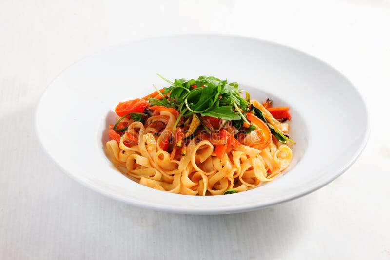 Teigwaren mit Gemüse, Tomaten, Zucchini, Pfeffer, lokalisiert auf weißem HintergrundTomatensauce Rondemenü lizenzfreies stockbild Teigwaren mit Gemüse, Tomaten, Zucchini, Pfeffer, lokalisiert auf weißem HintergrundTomatensauce Rondemenü lizenzfreies stockbild