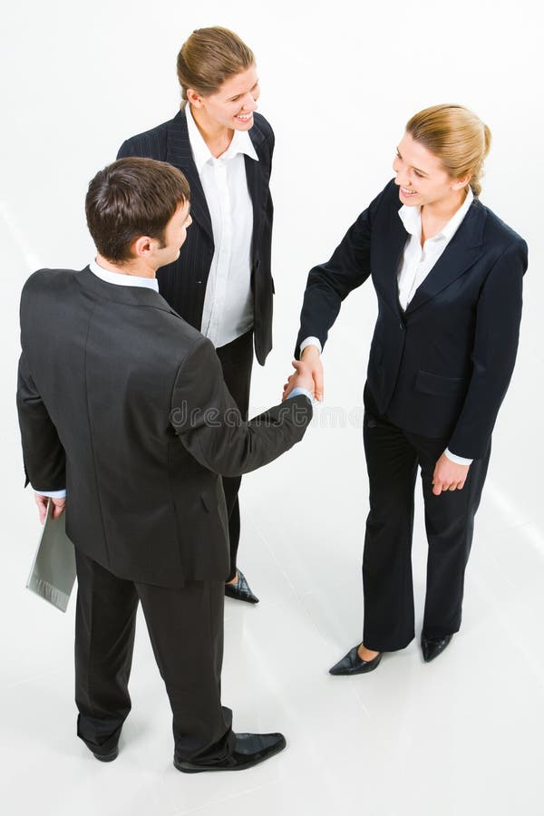 Image of successful partners shaking hands in the white room. Image of successful partners shaking hands in the white room