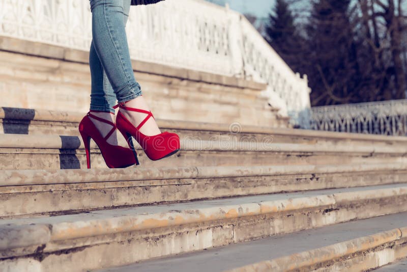 Tejanos que llevan de la mujer y zapatos rojos del tacón alto en ciudad vieja El paseo de los tacones altos de la ropa de mujer e imágenes de archivo libres de regalías Tejanos que llevan de la mujer y zapatos rojos del tacón alto en ciudad vieja El paseo de los tacones altos de la ropa de mujer e imágenes de archivo libres de regalías