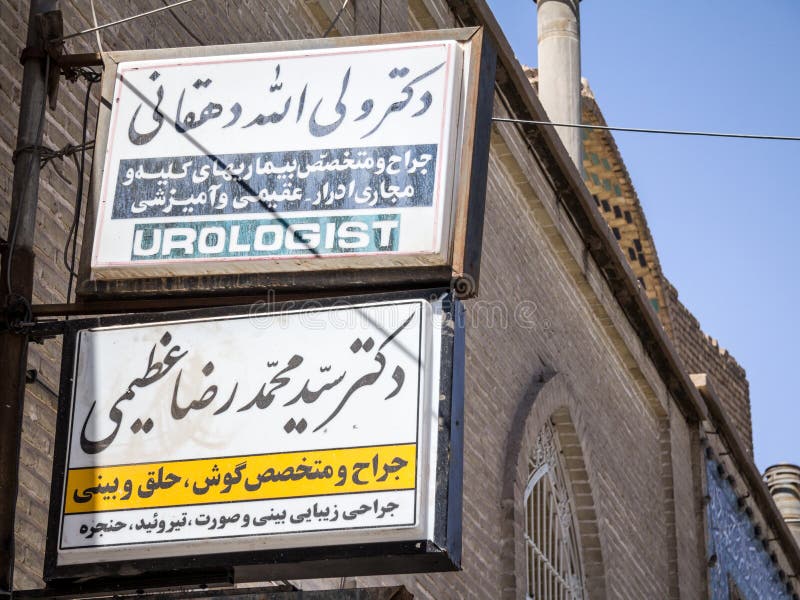 Teken die op het bureau van een Uroloog, zowel in Engelse als in Iraanse Farsi wijzen stock afbeeldingen Teken die op het bureau van een Uroloog, zowel in Engelse als in Iraanse Farsi wijzen stock afbeeldingen