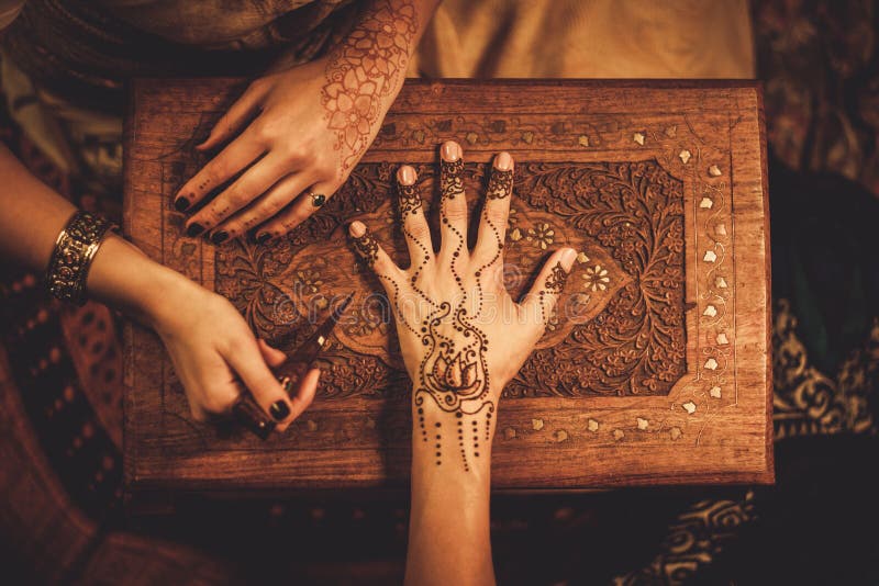 Drawing process of henna menhdi ornament on woman's hand. Drawing process of henna menhdi ornament on woman's hand