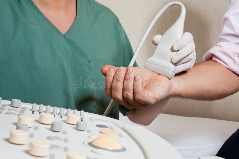 Midsection of radiologic technician scanning male patient's hand. Midsection of radiologic technician scanning male patient's hand