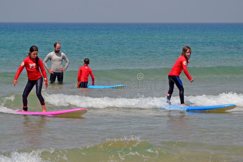 Tel Aviv, Israel - 04/05/2017: Las muchachas están compitiendo con a lo largo de la onda en el mediterráneo Escuela que practica imagen de archivo Tel Aviv, Israel - 04/05/2017: Las muchachas están compitiendo con a lo largo de la onda en el mediterráneo Escuela que practica imagen de archivo