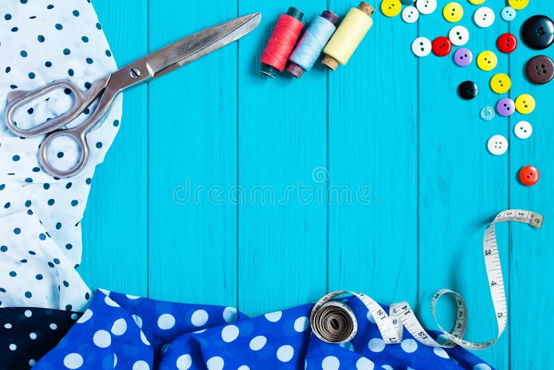 Telas pontilhadas, tesouras, botões, fita de medição, na turquesa fotografia de stock Telas pontilhadas, tesouras, botões, fita de medição, na turquesa fotografia de stock