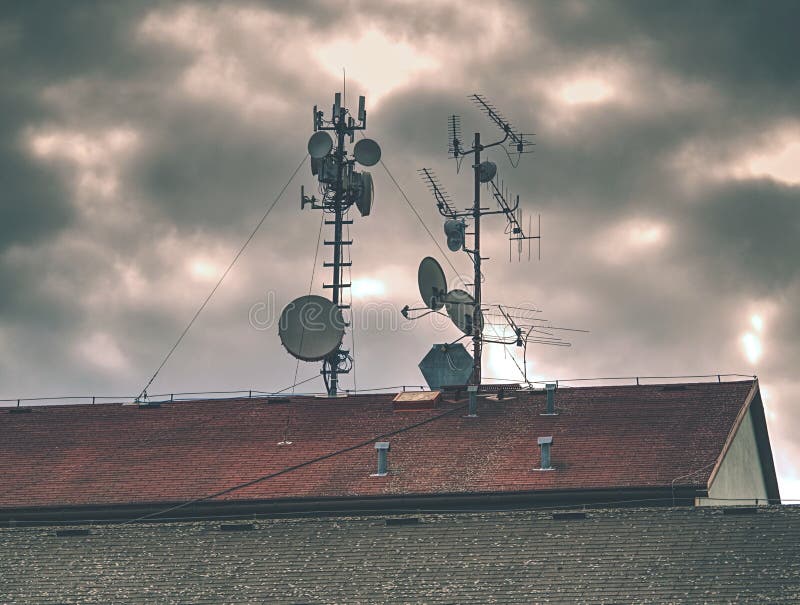 Telecommunication equipment with TV antennas, satellite dish and microwave antennas, broadcasting, cell, cellular, city, connection, electromagnetic, flying, frequency, gear, global, antena, architecture, background, brick, brown, cable, channel, chimney, design, aerial, broadband, cloud, deck, gray, grey, home, information, internet, multimedia, network, program, radar, radio, receiver, residential, roof, signal, station, telecast, television, white, wire, wireless. Telecommunication equipment with TV antennas, satellite dish and microwave antennas, broadcasting, cell, cellular, city, connection, electromagnetic, flying, frequency, gear, global, antena, architecture, background, brick, brown, cable, channel, chimney, design, aerial, broadband, cloud, deck, gray, grey, home, information, internet, multimedia, network, program, radar, radio, receiver, residential, roof, signal, station, telecast, television, white, wire, wireless