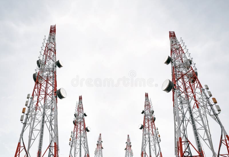 Telecommunication towers with TV antennas and satellite dish on clear sky, black and white