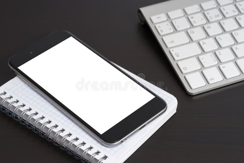 Telefon na notepad na zmroku stole. Telefon na notepad na zmrok klawiaturze i stole