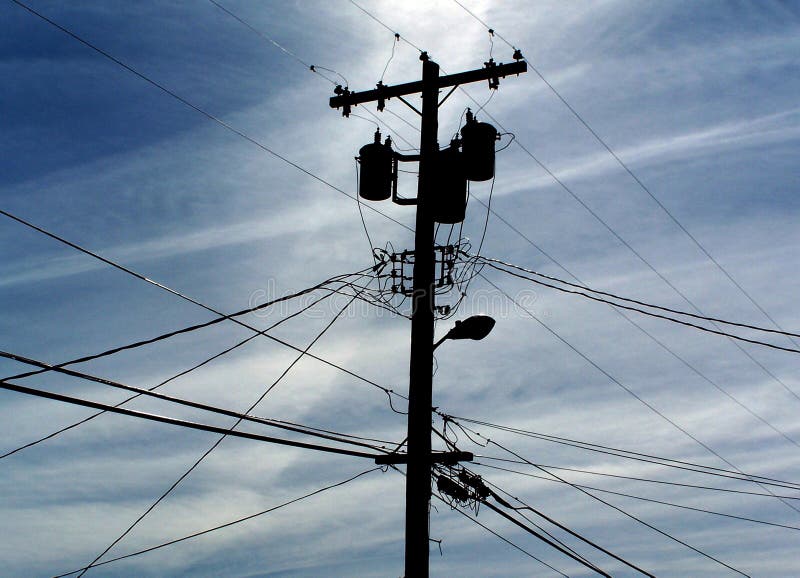 A telephone pole silhouetted against a blue sky. A telephone pole silhouetted against a blue sky.