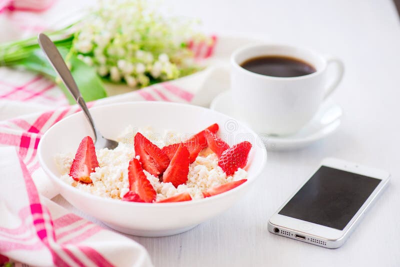 Telefon und Tasse Kaffee mit Platte des Hüttenkäses mit strawb lizenzfreie stockfotografie Telefon und Tasse Kaffee mit Platte des Hüttenkäses mit strawb lizenzfreie stockfotografie