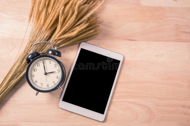 Telefone esperto do despertador retro e da tabuleta digital no fundo de madeira imagens de stock royalty free Telefone esperto do despertador retro e da tabuleta digital no fundo de madeira imagens de stock royalty free