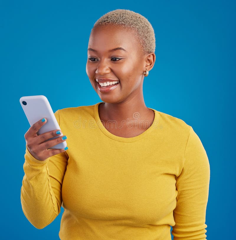 Mulher sorrindo e digitando no smartphone no estúdio lendo mídias