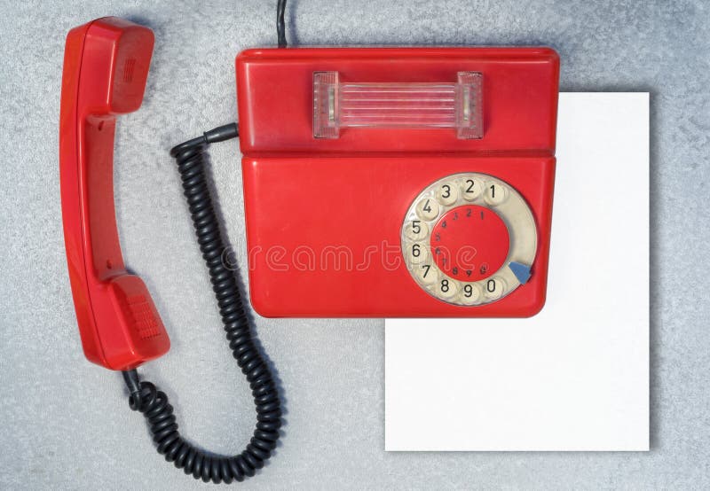 Telefone giratório antigo vermelho com a folha de papel vazia imagem de stock royalty free Telefone giratório antigo vermelho com a folha de papel vazia imagem de stock royalty free