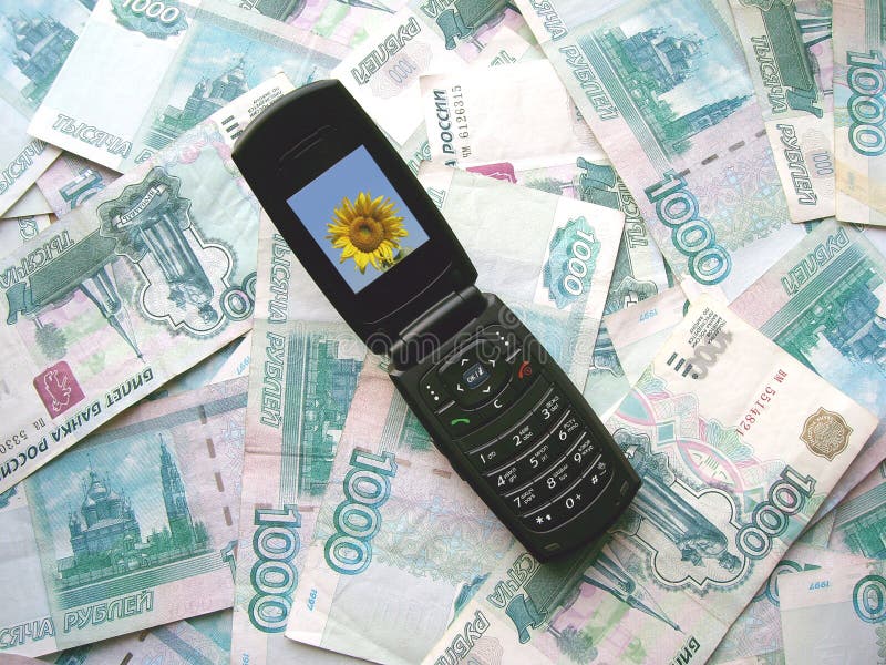 Telefone móvel que coloca em notas de banco de Rússia fotos de stock Telefone móvel que coloca em notas de banco de Rússia fotos de stock