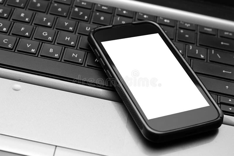 Telefono cellulare sulla tastiera del computer portatile fotografia stock libera da diritti Telefono cellulare sulla tastiera del computer portatile fotografia stock libera da diritti