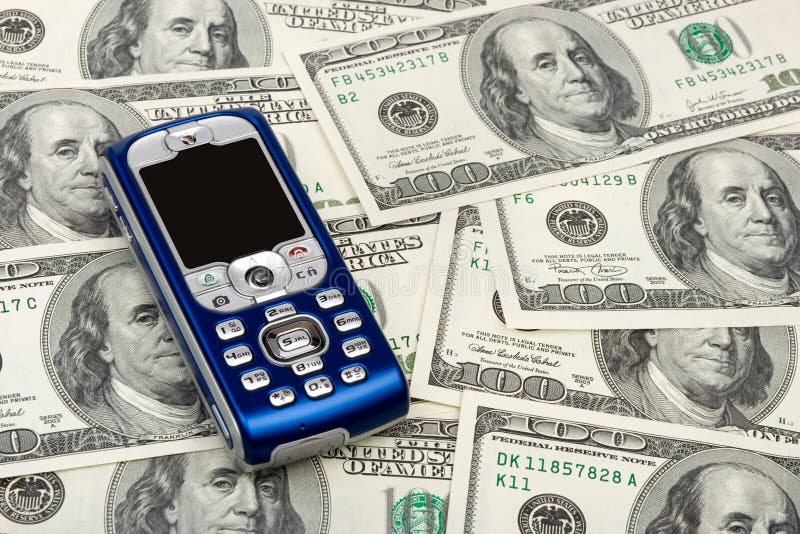 Telefono mobile sulla priorità bassa dei soldi fotografie stock Telefono mobile sulla priorità bassa dei soldi fotografie stock
