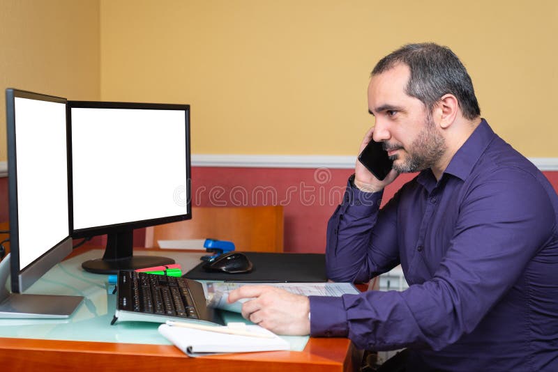 40s man with smartphone teleworking in house. 40s man with smartphone teleworking in house.